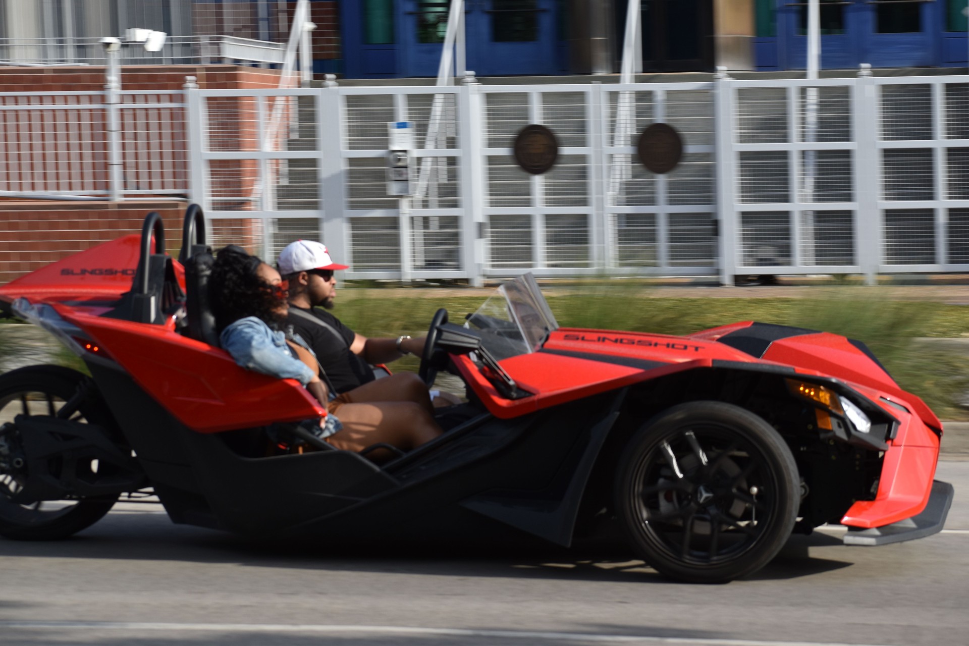 A portrait of a Polaris Slingshot cruising in the downtown district of Houston